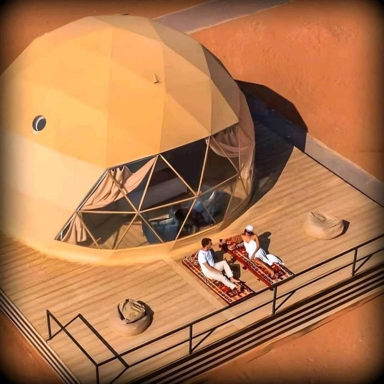 two people sitting on the deck of a boat at Tamim Luxury wadi rum camp in Wadi Rum