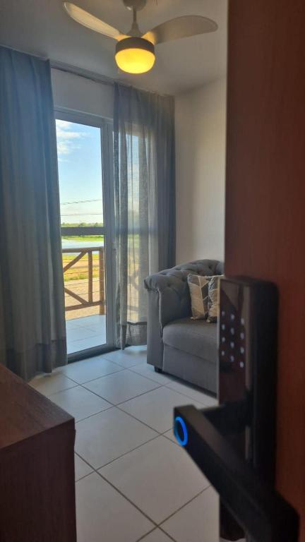 a living room with a couch and a sliding glass door at Brisas do Lago II in Paulo Afonso