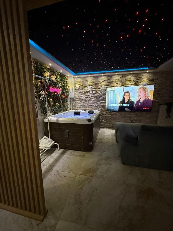 a large bathroom with a tub and a tv at Maison in Maisdon-sur-Sèvre