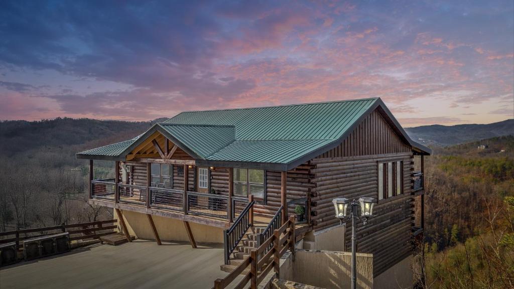 a log cabin with a green roof on a deck at Soaring Views Lodge in Sevierville