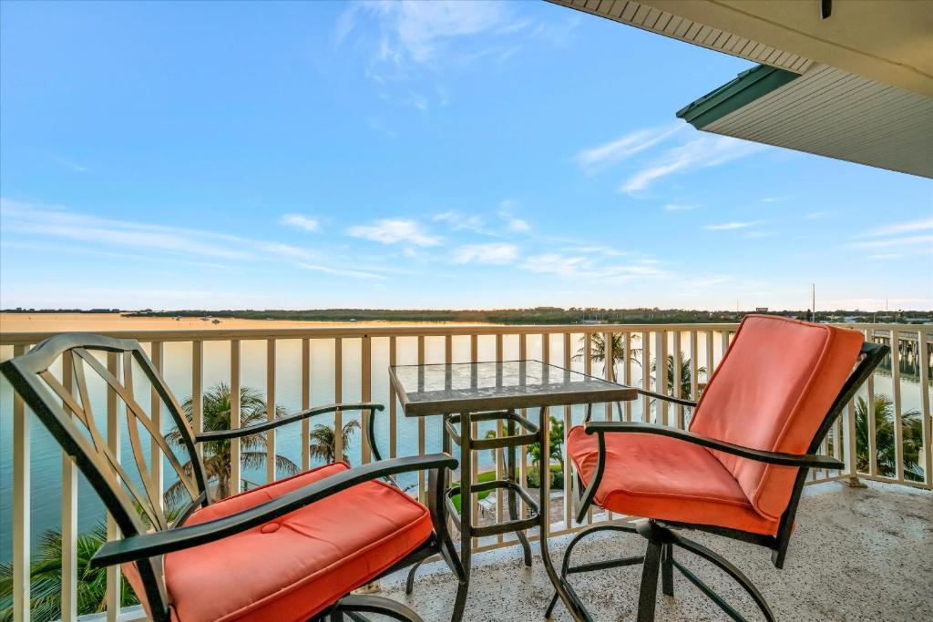 a patio with two chairs and a table on a balcony at Sunsets Waterview Balcony King Bed & Heated Pool in St. Petersburg