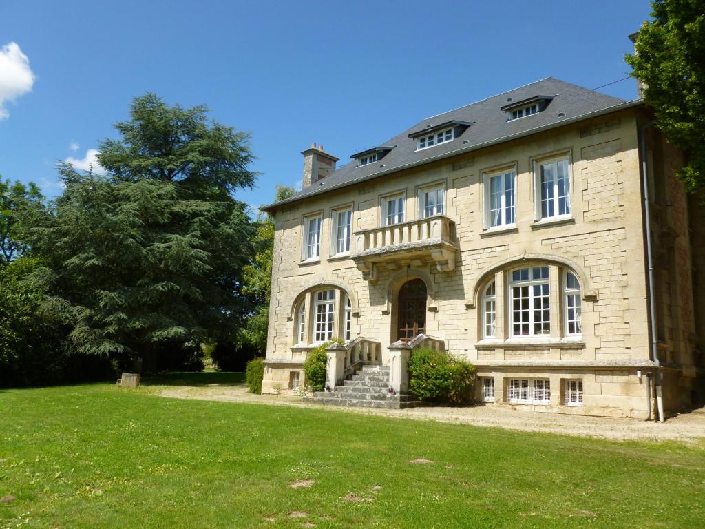 una vecchia casa in pietra su un prato di La chambre au Château a Pernant