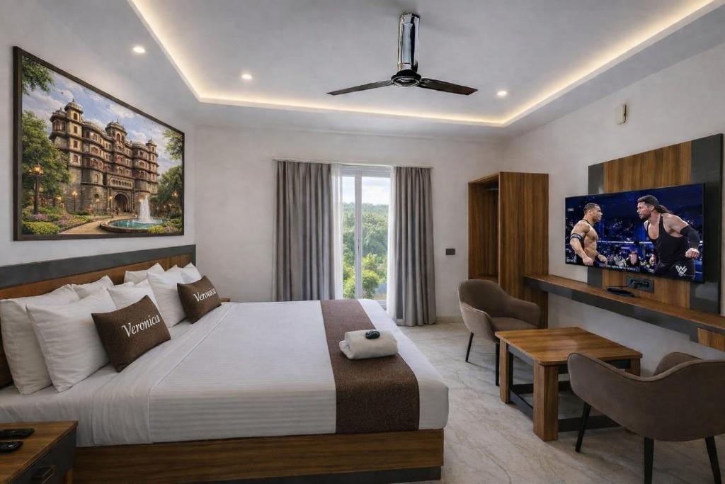 a hotel room with a bed and a desk at Hotel Veronica in Indore