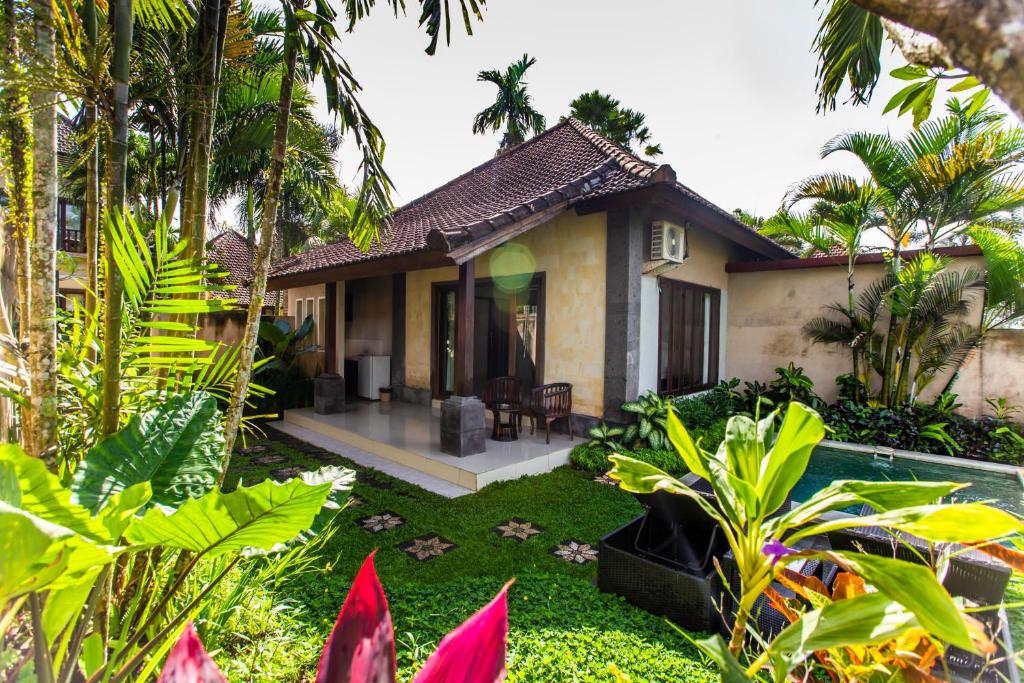 a house with a garden and a swimming pool at Warung Mandi & Villa in Ubud