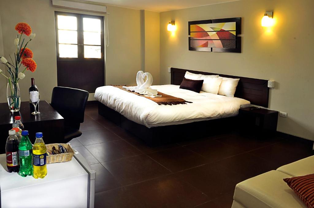una habitación de hotel con una cama y una mesa con bebidas en Hoteles Riviera Mansion, en Arequipa