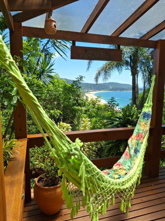 a hammock on a deck with a view of the ocean at Suíte Vista Mar Praia Estaleiro Balneário Camboriú in Balneário Camboriú