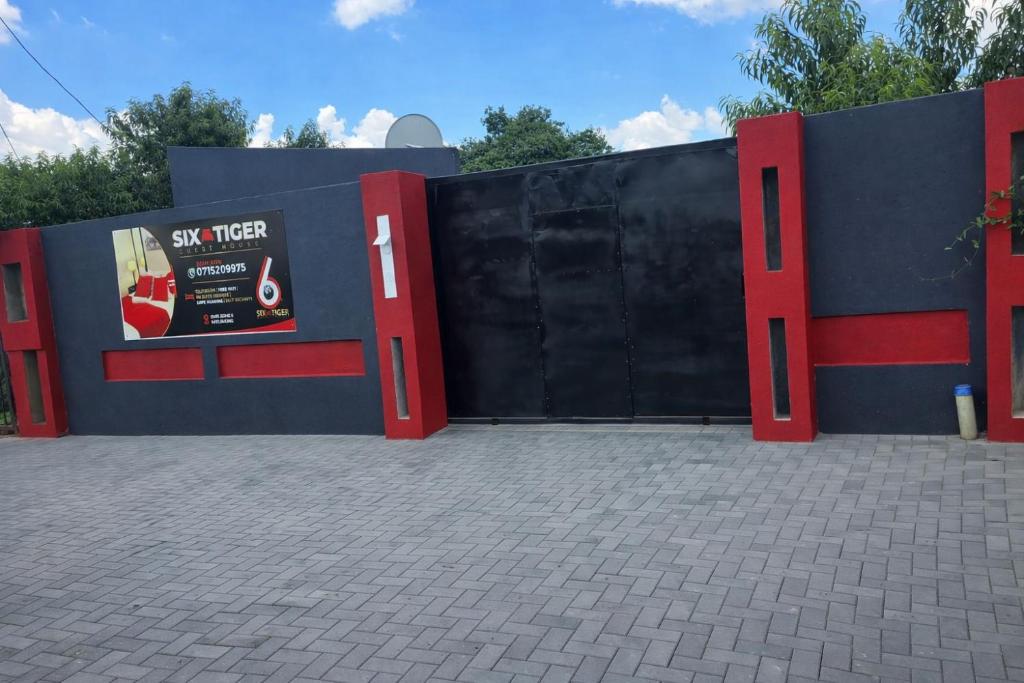 a black and red wall with a black gate at 6 Tiger guest house in Katlehong