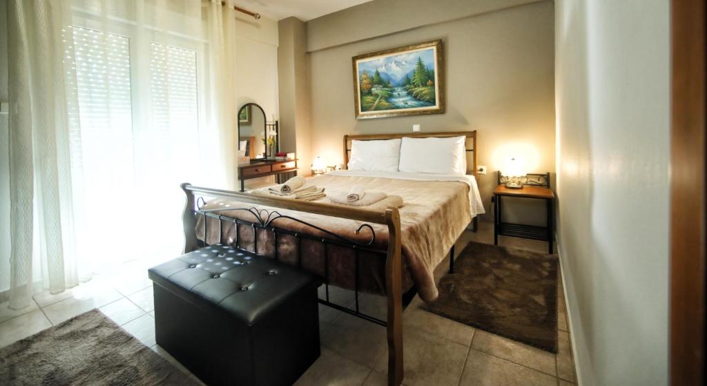 a bedroom with a bed and a stool next to a window at The Bliss Z1 in Kastoria