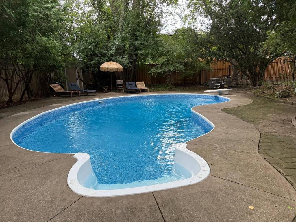 a swimming pool with blue water in a yard at Spacious 4-Bedrooms Friendly House-Pool-Parking in Markham