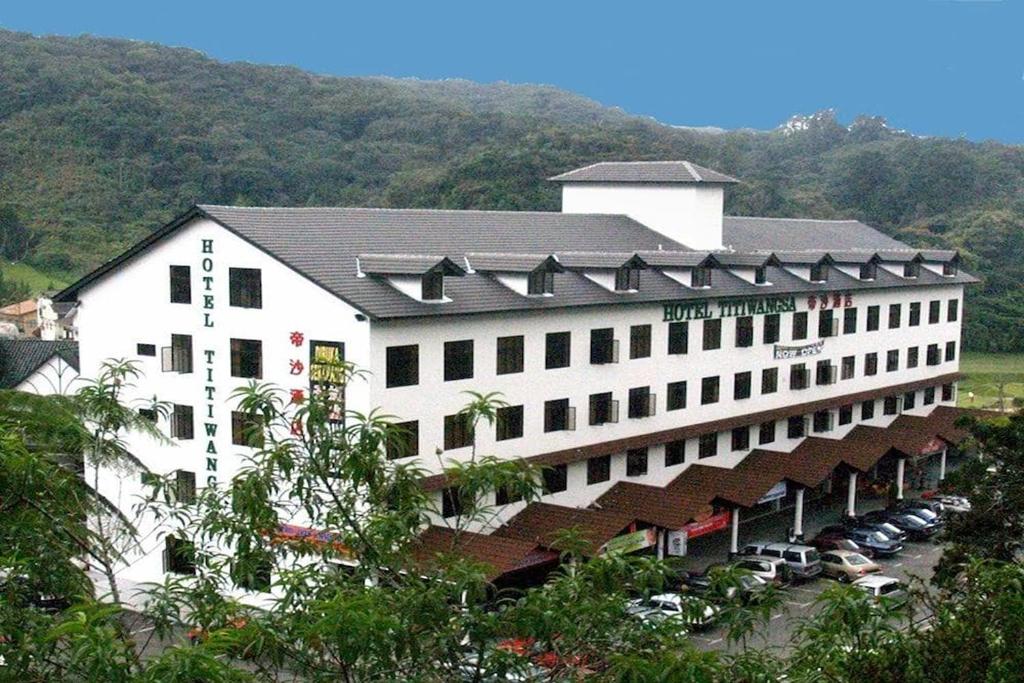 a large white building with cars parked in front of it at Hotel Titiwangsa in Brinchang