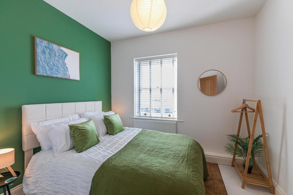 a bedroom with a large bed with green walls at Spacious 2-Bed Flat with Panoramic Views in Portsmouth