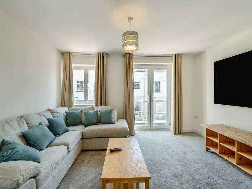 a living room with a couch and a flat screen tv at Beachside Bliss in Paignton
