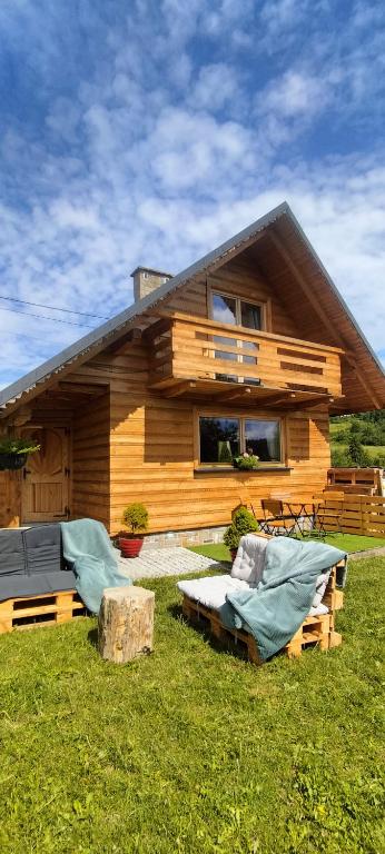 a log cabin with a porch and a house at Chata Ku Tatrom in Biały Dunajec