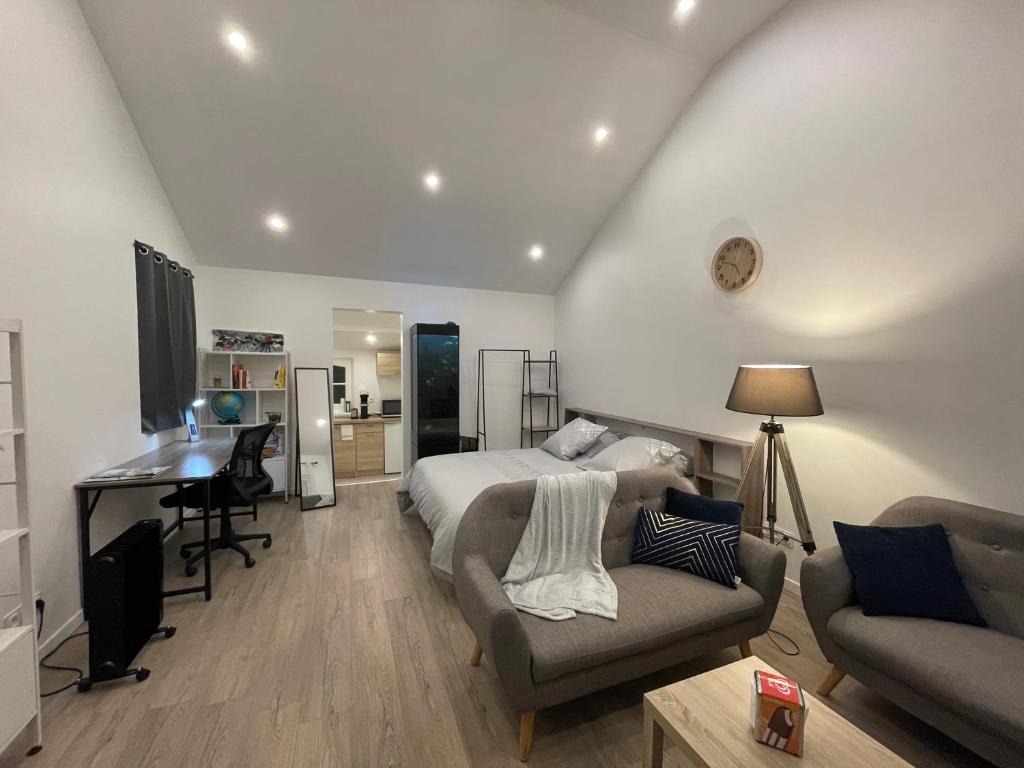 a bedroom with a bed and a couch and a desk at Un cocoon spacieux in Les Essarts-le-Roi
