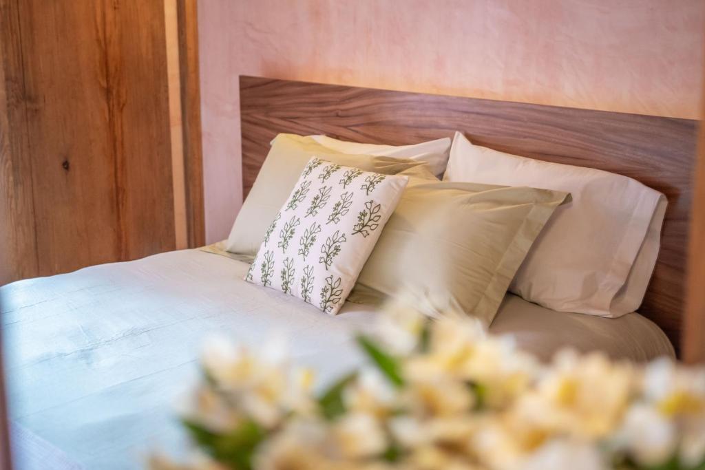 a bed with white sheets and pillows and flowers at Hotel Casa de las Abuelas in Guanajuato