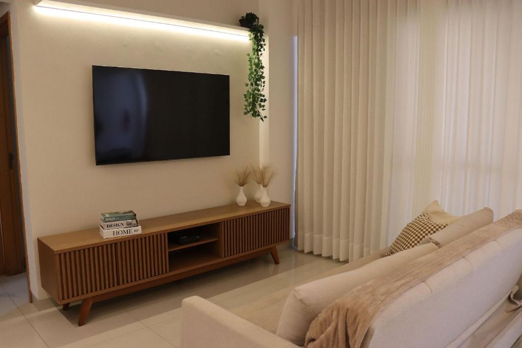 a living room with a television on a wall at Design e Amor no Centro in Palmas