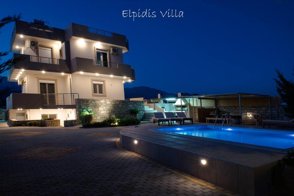 a villa with a swimming pool at night at Elpidis Villa in Kokkinos Pirgos