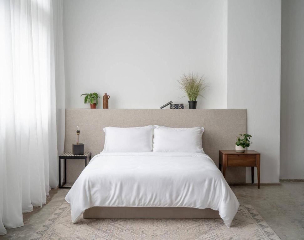 a bedroom with a large white bed with white pillows at COZY ROOM - between Malmö & Lund in Lund
