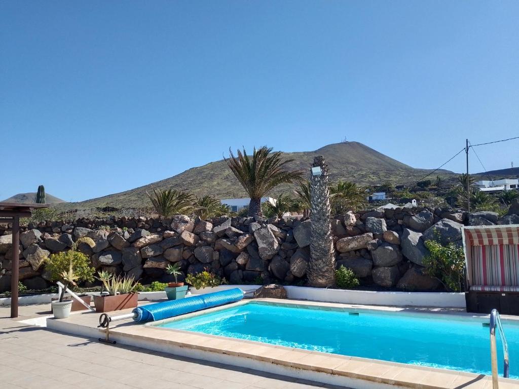 a swimming pool in front of a rock wall at HelgaHome in Las Breñas
