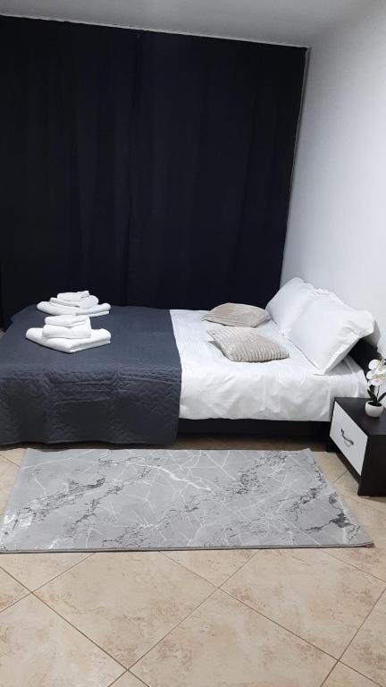 a bedroom with a large bed with a black wall at White Apartment in Bîrlad