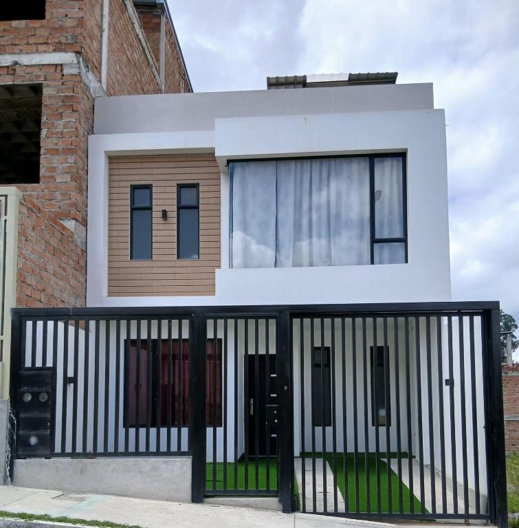 a house with a black and white fence at Casa moderna, amplia y acogedora Valentina in Loja