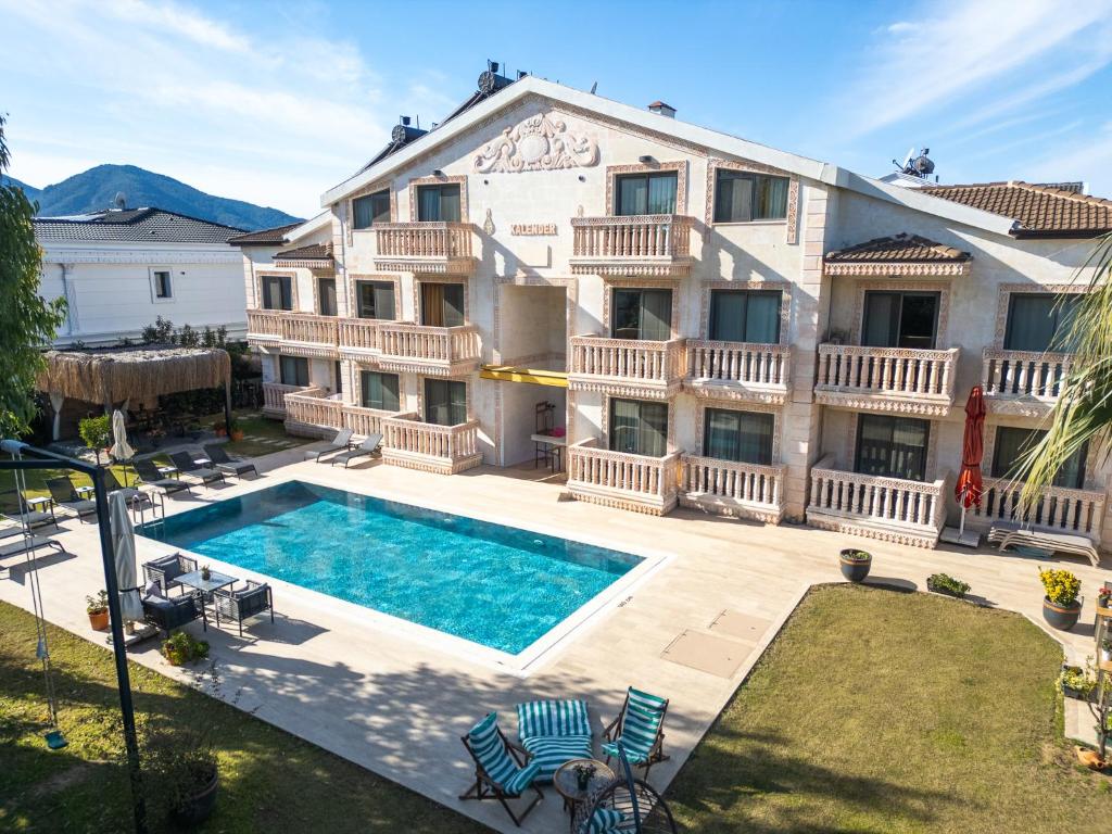 a large house with a swimming pool in front of it at Kalender Pansiyon Fethiye in Fethiye