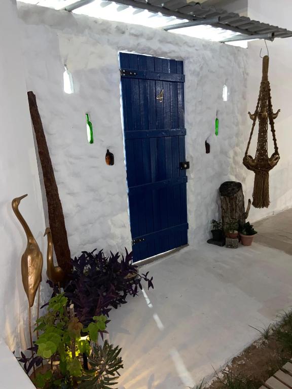 a blue door on a white building with plants at Pousada Nosso Sonho in Natal