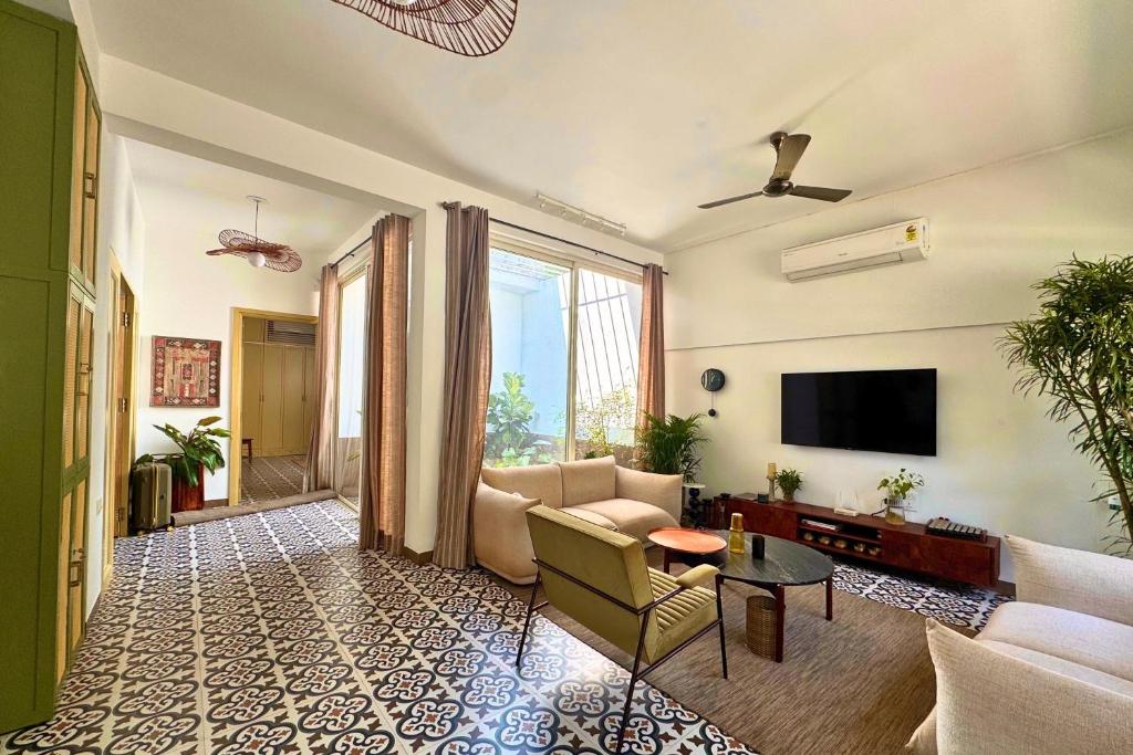 a living room with a couch and a tv at A Modern 2BHK Private Villa in Vagator - Valenades in Vagator