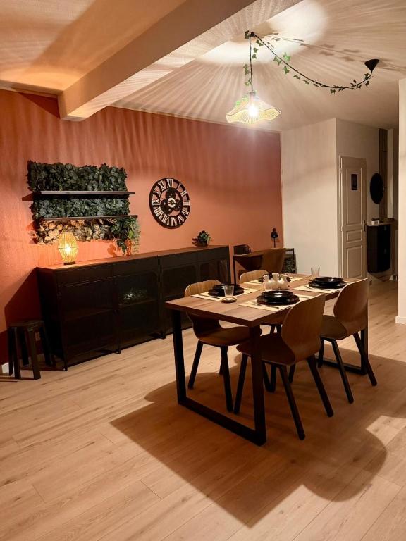 ein Esszimmer mit Tisch und Stühlen und einer Uhr in der Unterkunft Thejungle in Freyming