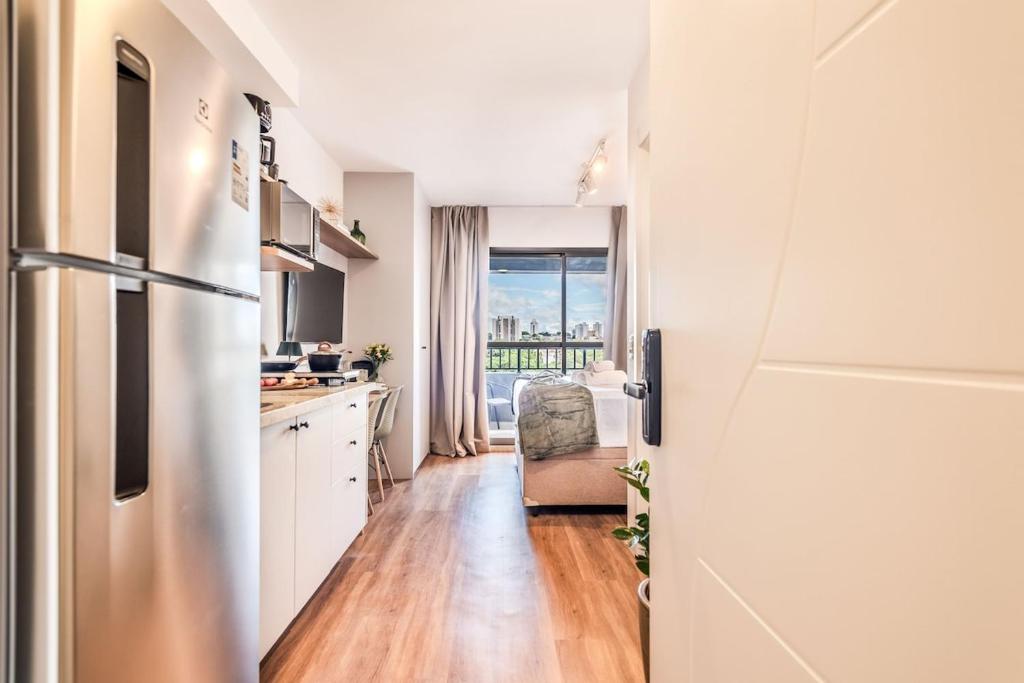 a kitchen with white cabinets and a refrigerator at Studio SP Congonhas, CEIC-Itaú, Expo-SP in São Paulo