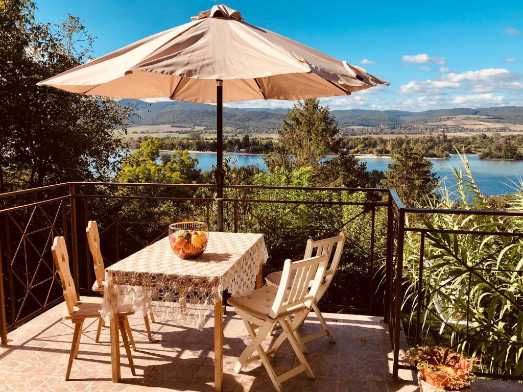 a table and chairs with an umbrella on a patio at Repülőhal Apartmanház in Zebegény