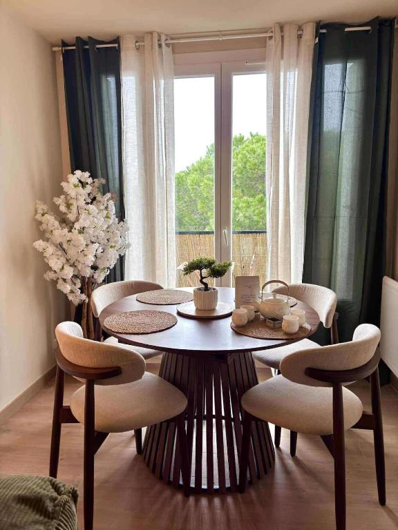 a dining room with a table and chairs and a window at Sakura Seaside -Expérience Japonaise en bord de mer in Argelès-sur-Mer