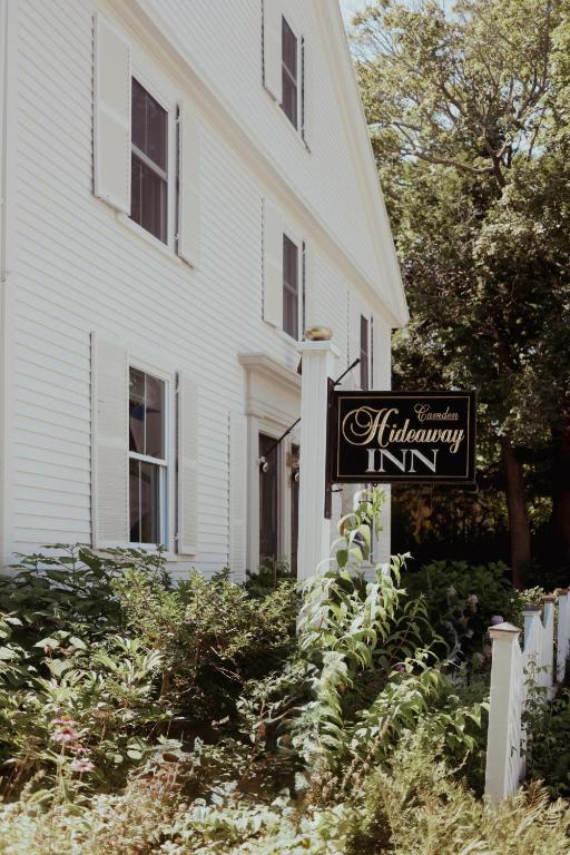a sign in front of a white house at Hideaway Inn Maine in Camden
