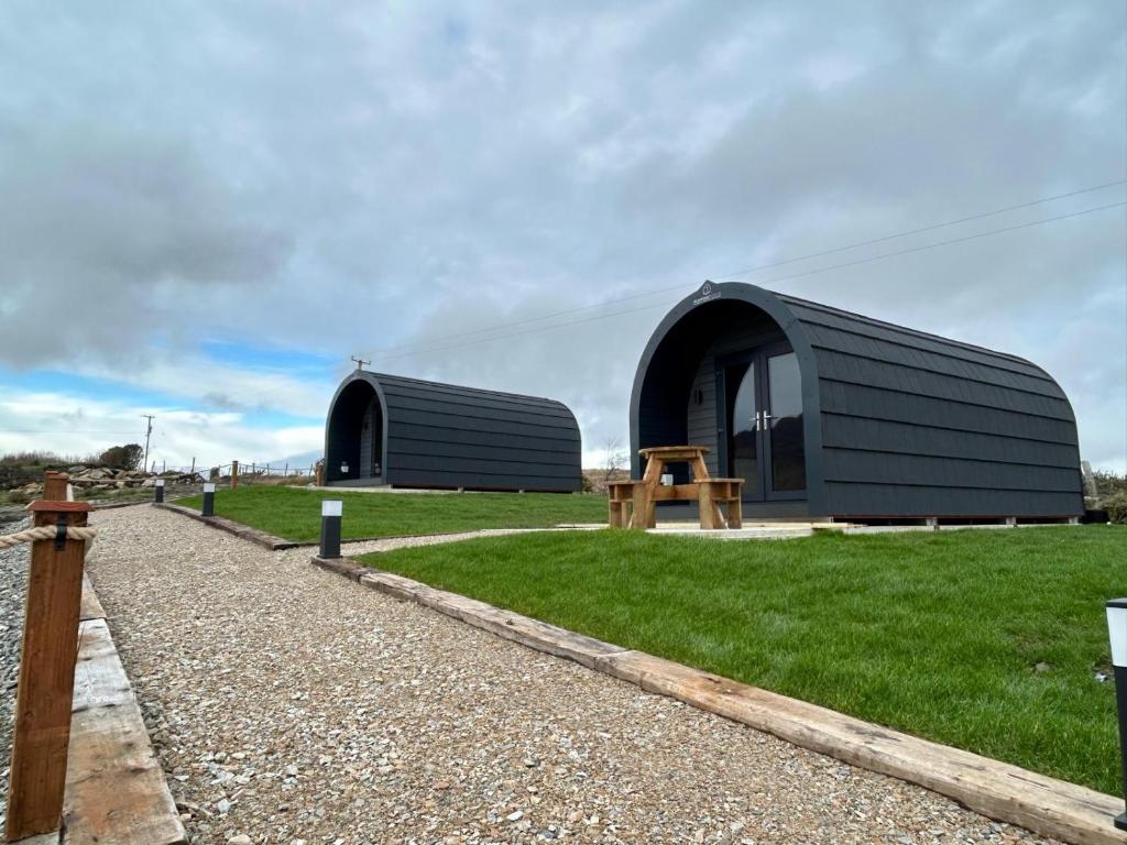a black dome shaped building with a table in the grass at Hilltop Glamping in Ardara