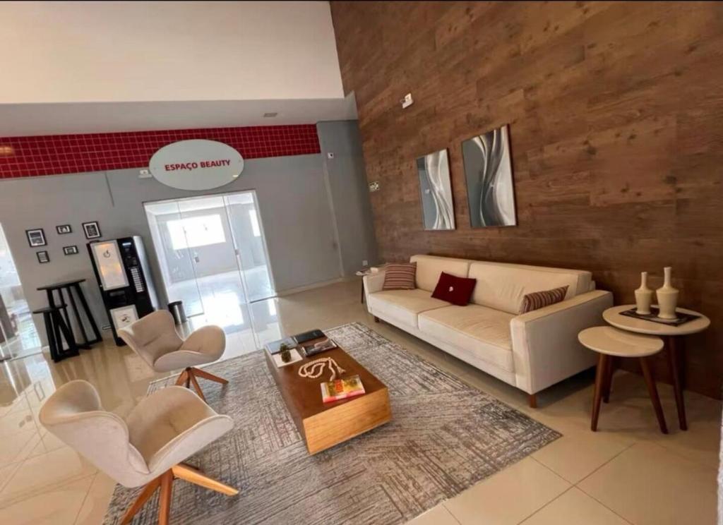 a living room with a couch and chairs and a table at Flat Red Encanto in Sorocaba