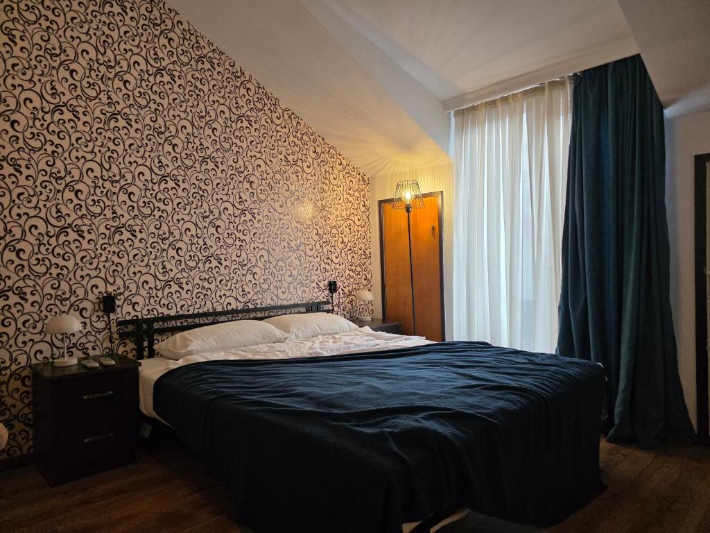 a bedroom with a bed with a patterned wall at Urban House in Batumi