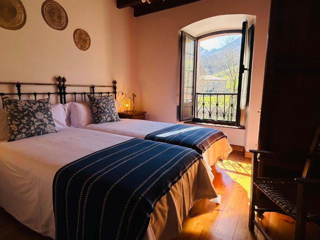 a bedroom with a bed and a large window at Casa Caiceda in Poo de Cabrales