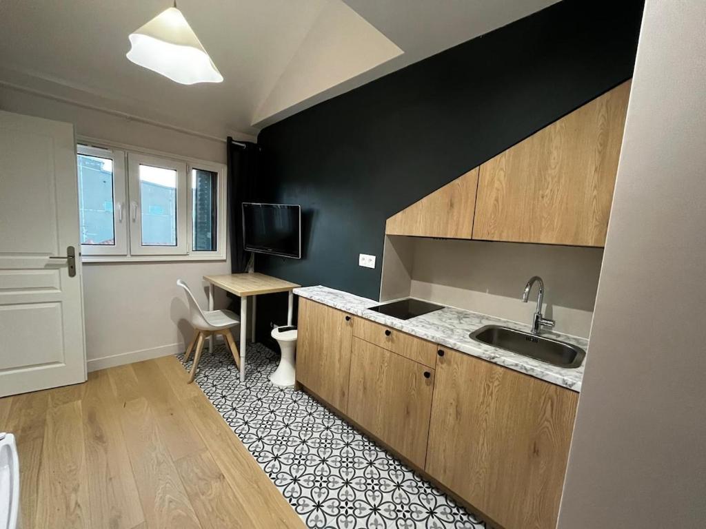 a kitchen with a sink and a desk at Studio moderne Arcueil in Arcueil