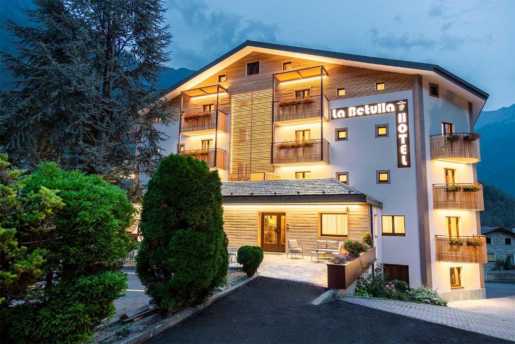 a large building with a sign on the side of it at Meublè La Betulla in Chiesa in Valmalenco