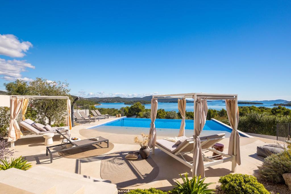 a villa with a pool and lounge chairs at Villa Pirata in Jezera