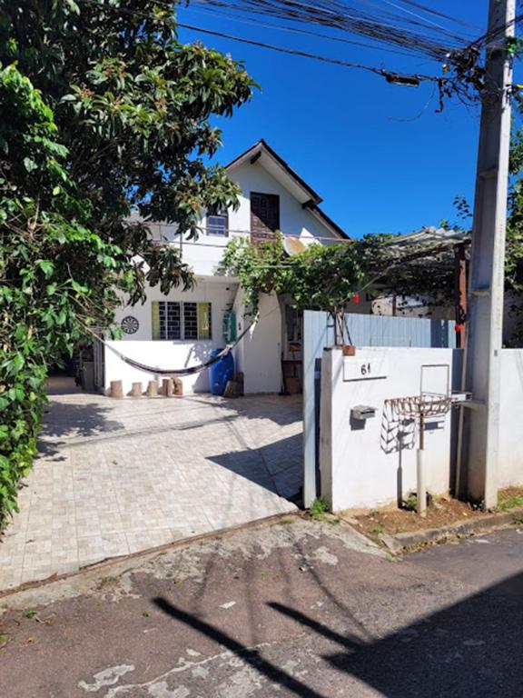 a white house with a fence and a driveway at Casa 2000 Positivo UTFPR INC Volvo in Curitiba