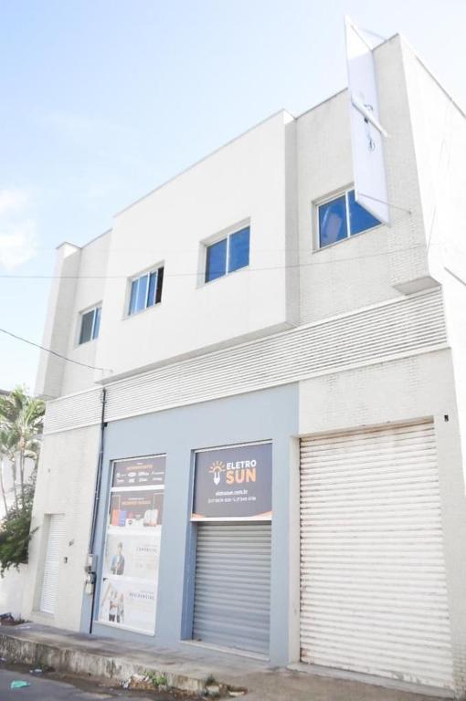 a white building with a garage door in front of it at Apartamento quarto e sala em campo grande in Cariacica