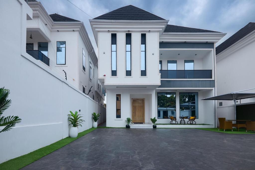 a white house with a courtyard in front of it at Buddy's Court Luxury 5Bedroom,3 & 2bed Apartment in Ikeja