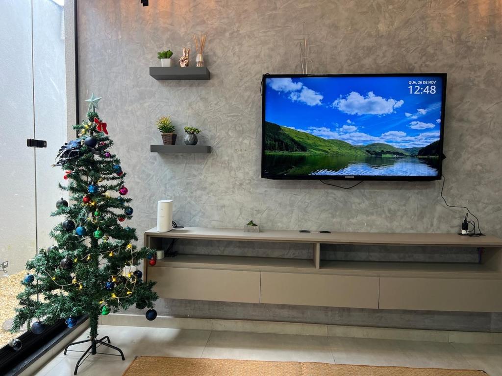 a living room with a christmas tree and a flat screen tv at Boa Vista · Amplo Ap. a 5 km do Hospital Regional Hans Dieter in Joinville
