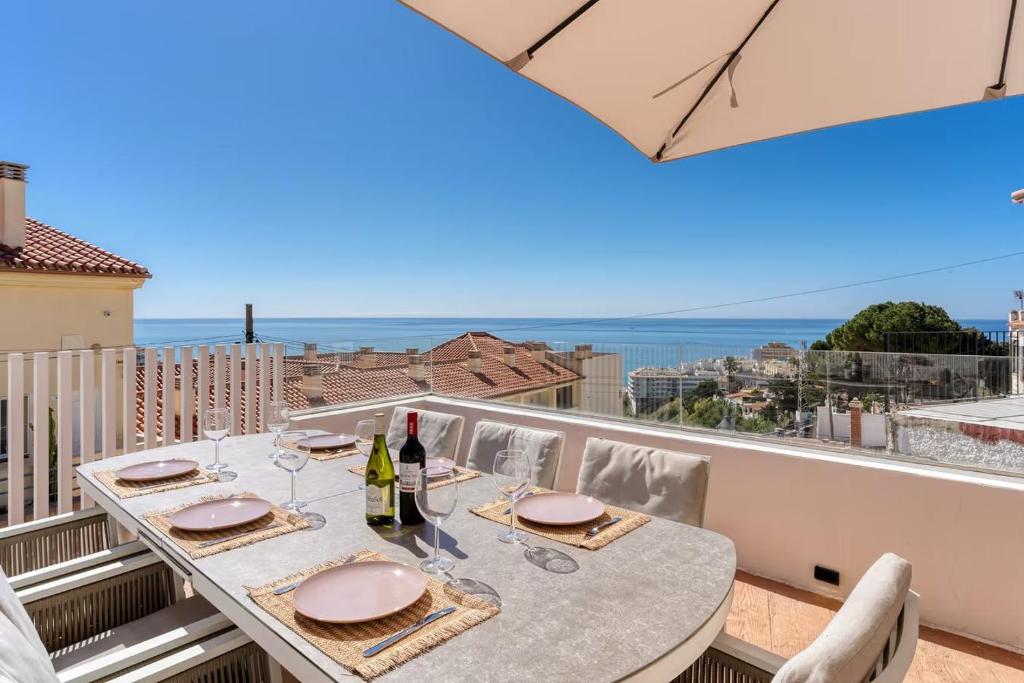 a table on a balcony with a view of the ocean at Villa Perdices in Fuengirola