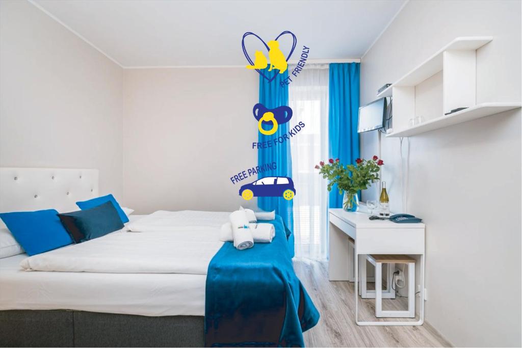 a bedroom with a large bed with blue curtains at Hotel Nowa Panorama in Krakow