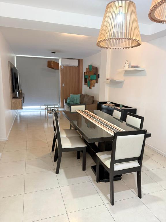 a dining room with a table and chairs and a piano at Cabildo Apart Familiar in Santiago del Estero