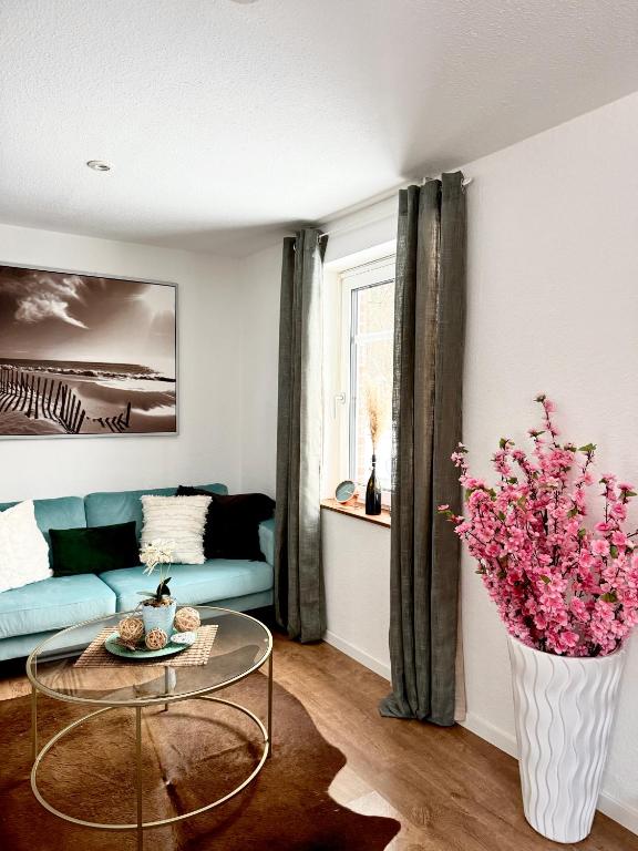 a living room with a couch and a vase of flowers at Mimos Ferienhaus in Meißendorf