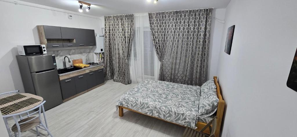 ein Zimmer mit einer Küche, in der ein Stuhl und ein Tisch stehen in der Unterkunft Studio Ajustorului rezidence ,Lacu Morii in Bukarest