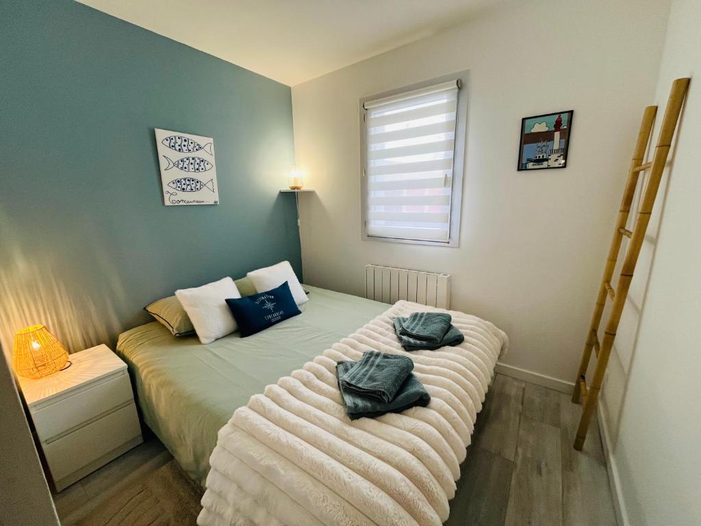 a bedroom with a bed with two towels on it at Au bord de l'eau in Concarneau